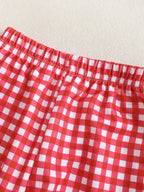 Red and white gingham baby and toddler pants with elastic waistband, close-up view