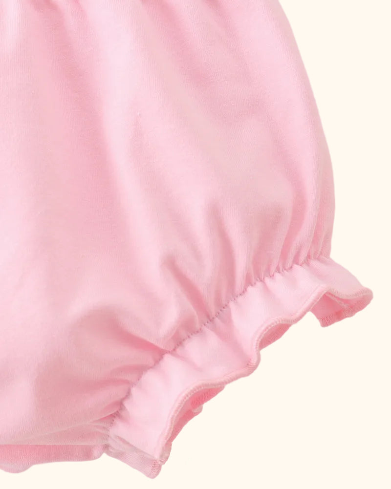 Pink baby bloomers with elasticized ruffle leg openings, close-up view