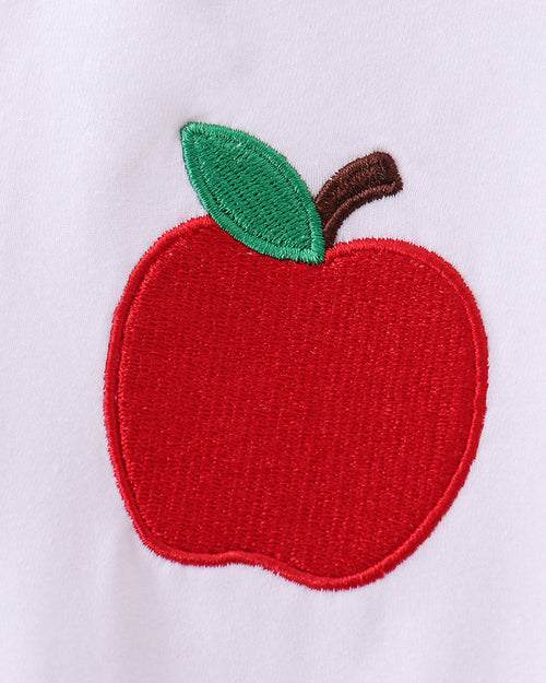 White kids T-shirt with red apple and green leaf embroidery, close-up view