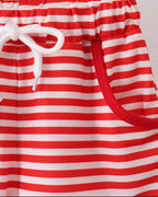 Red and white striped kids shorts with front pocket, elastic waist and white tie, close-up view