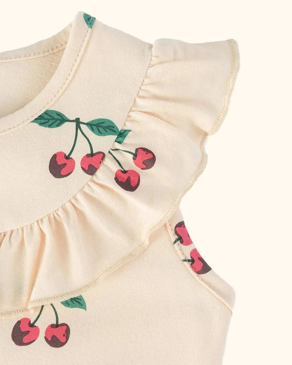 Apricot kids cherry print dress with flutter shoulder and gathered yoke ruffle, close-up view