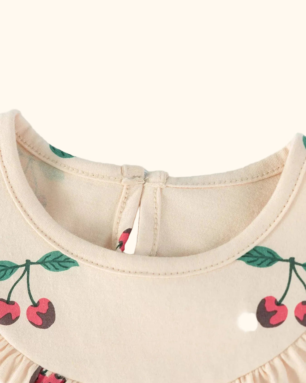 Apricot kids cherry print dress with round back neckline opening, neckline close-up