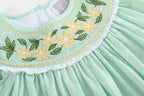 Aqua kids bishop dress with yellow daisy embroidery, green leaves and white lace trim, yoke close-up