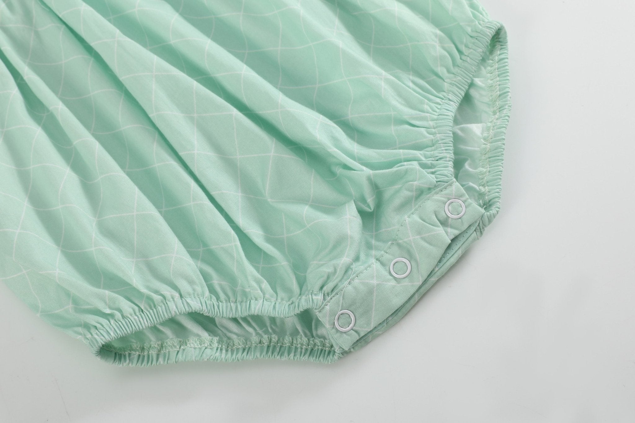 Aqua baby romper with elasticized leg openings and bottom snaps, close-up view