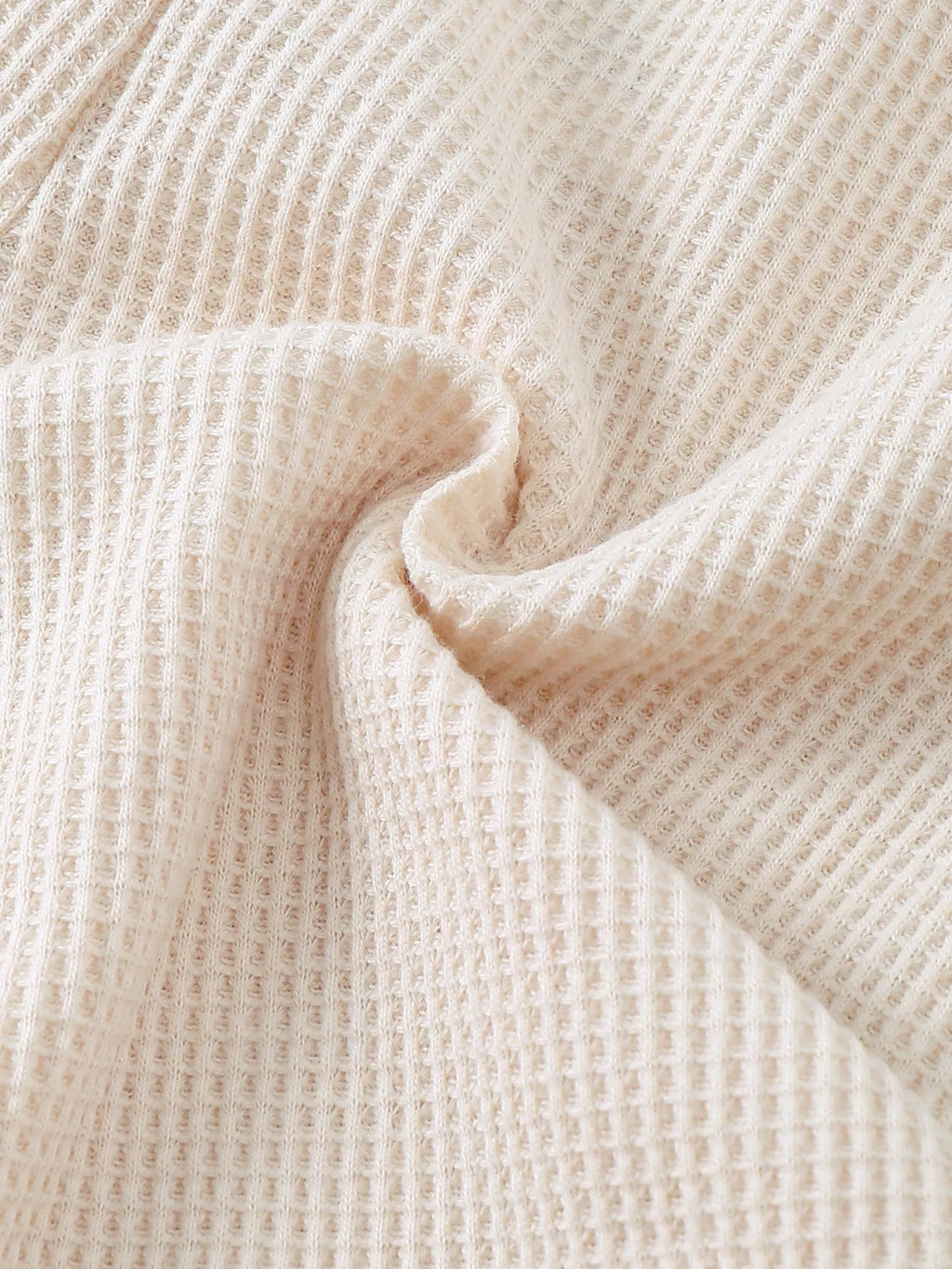 Ivory baby waffle knit fabric with raised textured grid pattern, fabric close-up