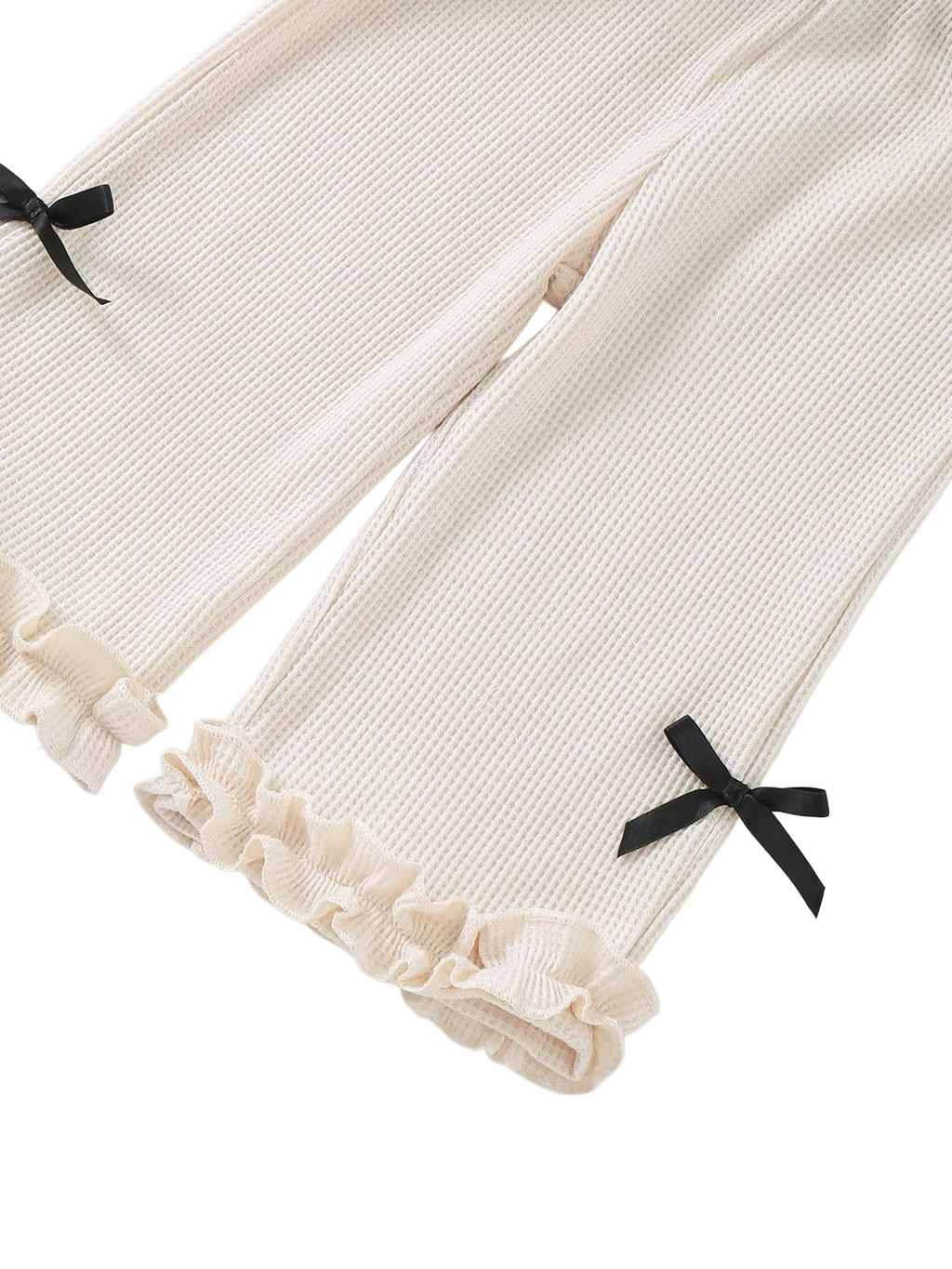 Ivory baby waffle knit wide-leg pants with black bow accents and double ruffle hems, pant-leg close-up