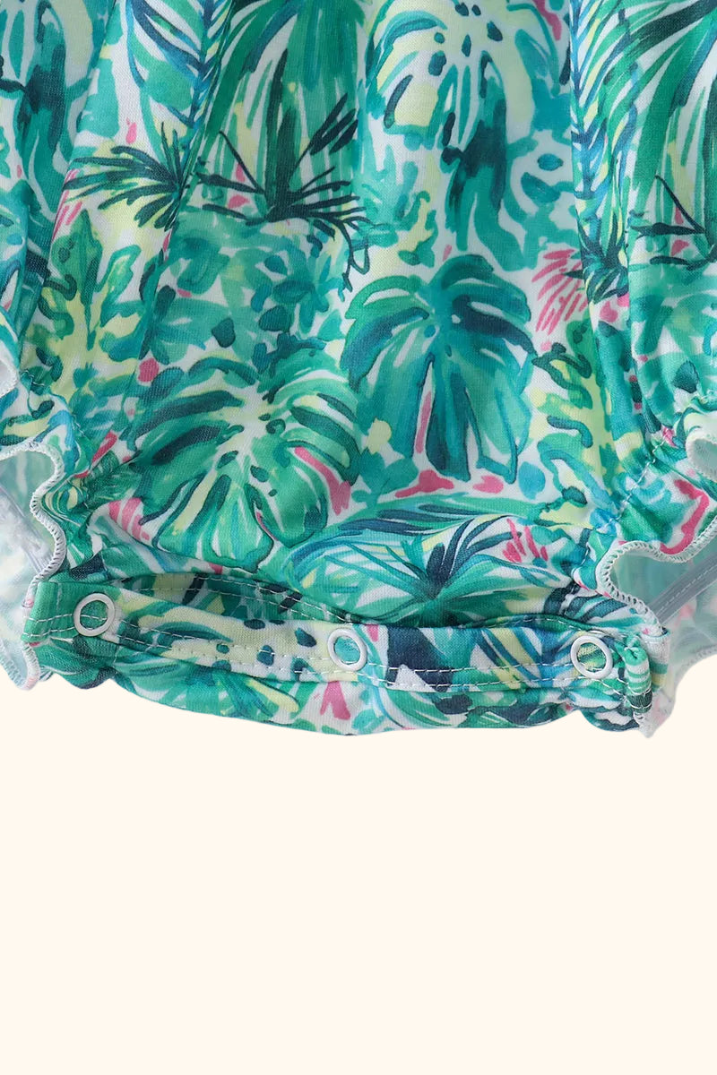 Green tropical baby bubble romper with bottom snap closure and elasticized leg detail, close-up view