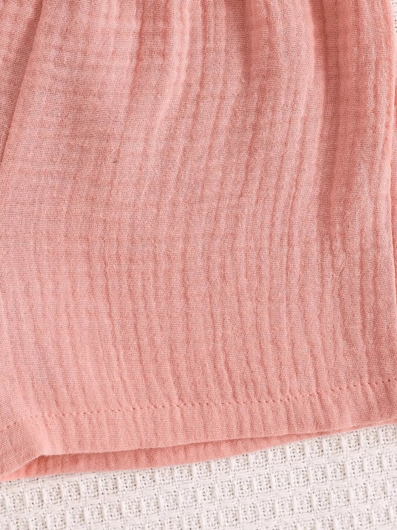 Pink baby cami and shorts set with crinkled textured fabric, fabric close-up