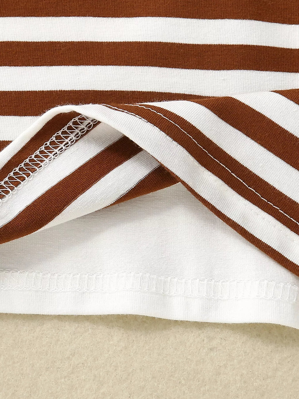 Chocolate baby striped T-shirt fabric with finished hem stitching, fabric close-up