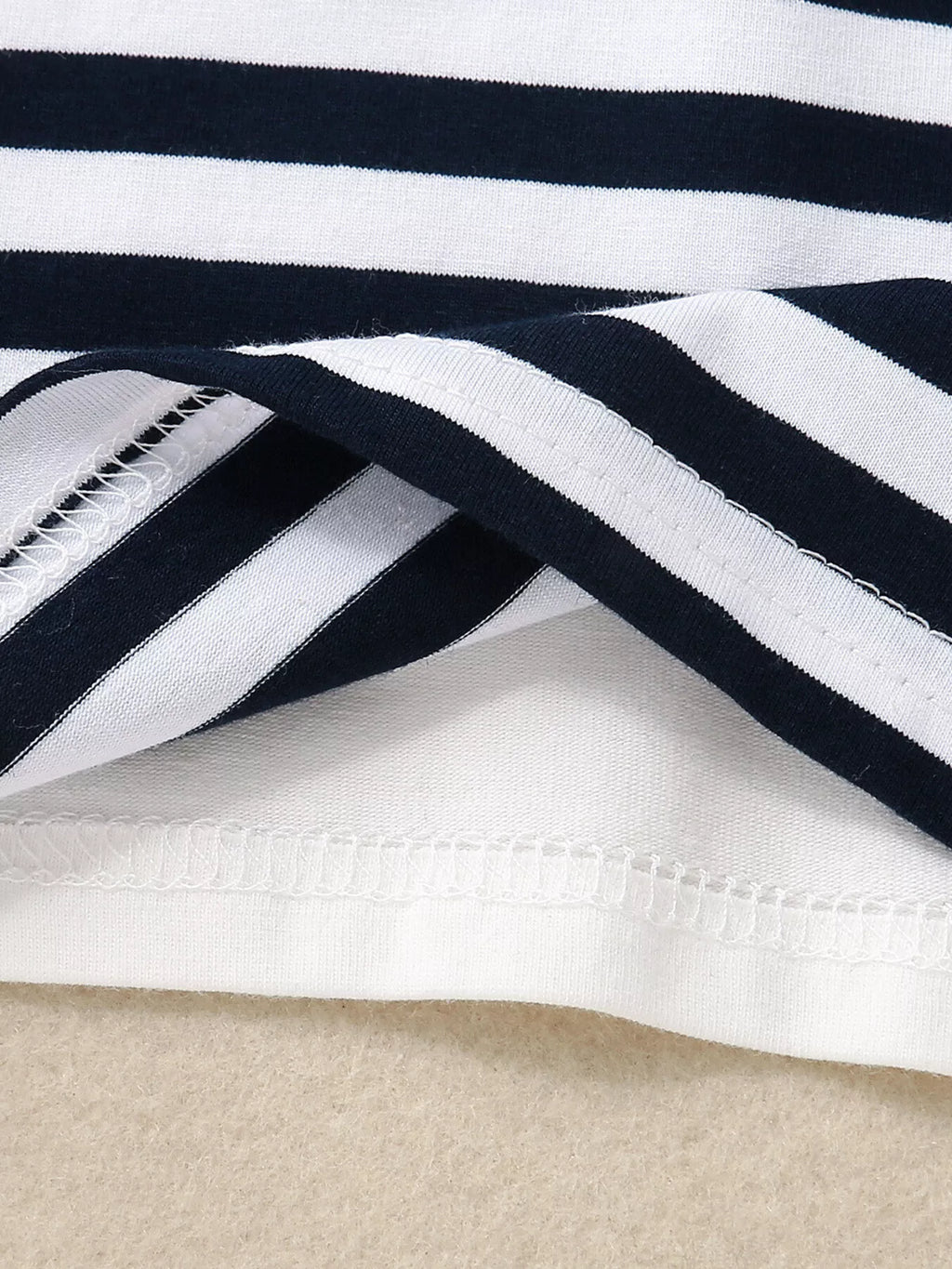 Dark blue baby striped T-shirt fabric with finished hem stitching, fabric close-up