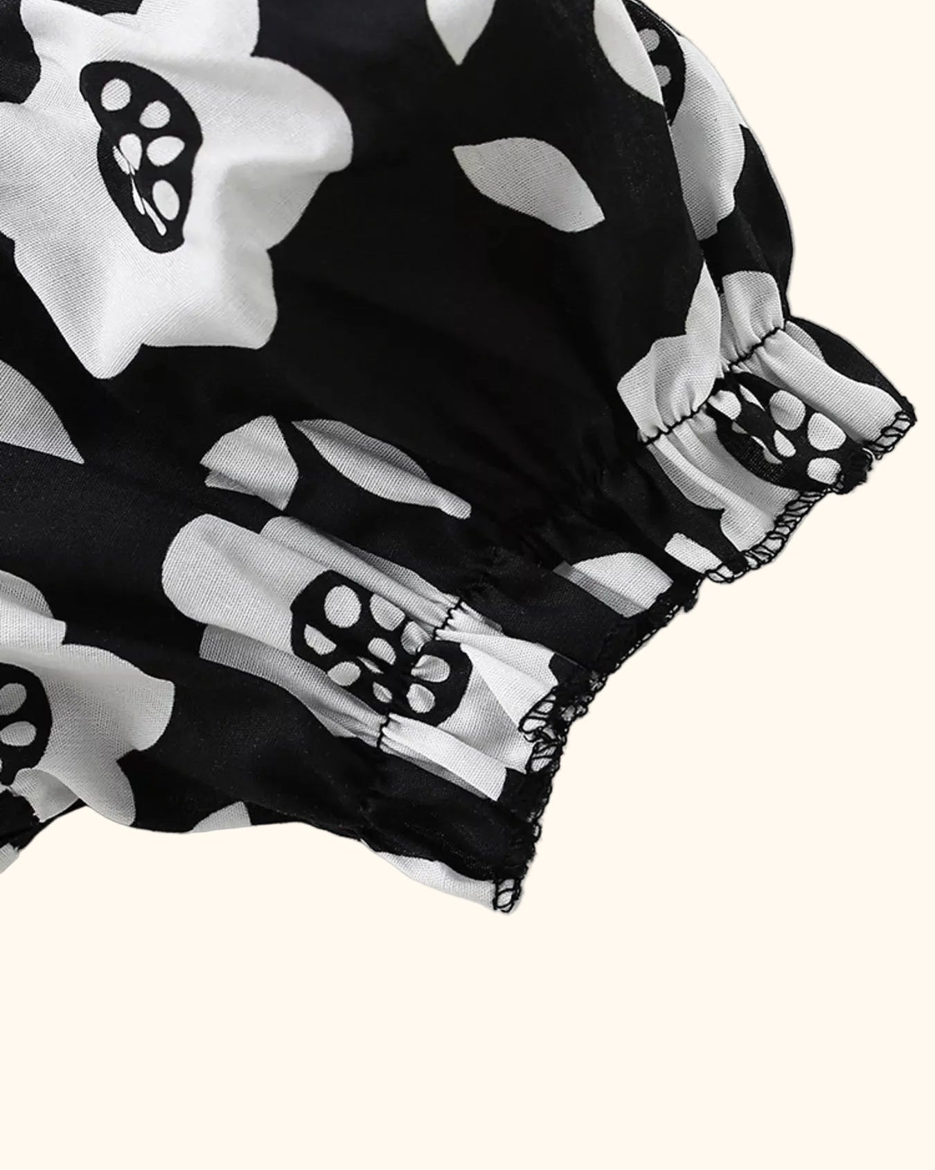 Black floral kids dress with elasticized puff sleeve and ruffled cuff, sleeve close-up