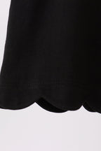 Black kids top with rounded scalloped bottom hem, close-up detail view