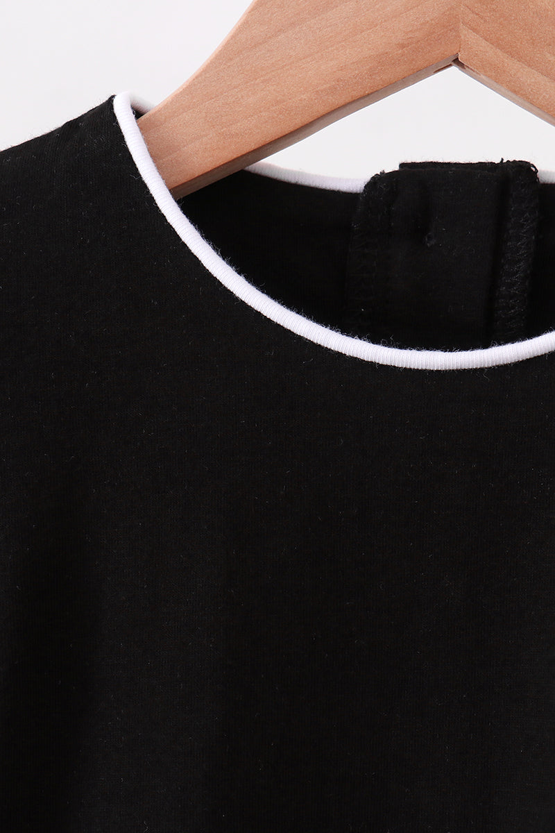 Black kids top with white-trim round neckline, close-up detail view