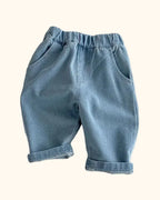 Blue kids elastic waist tapered trousers with front pockets and rolled cuffs, front view