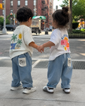 Blue baby and toddler tapered trousers with rolled cuffs and back graphic patch, modeled back view