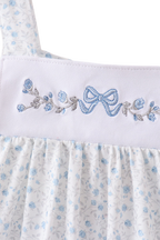 Blue floral kids top with bow and flower embroidery on white yoke, close-up front view