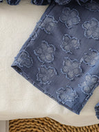 Blue baby wide-leg pants with raised flower motifs and straight hem, leg detail view