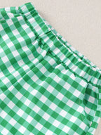 Green and white gingham baby shorts with elastic waistband and side pocket, close-up view
