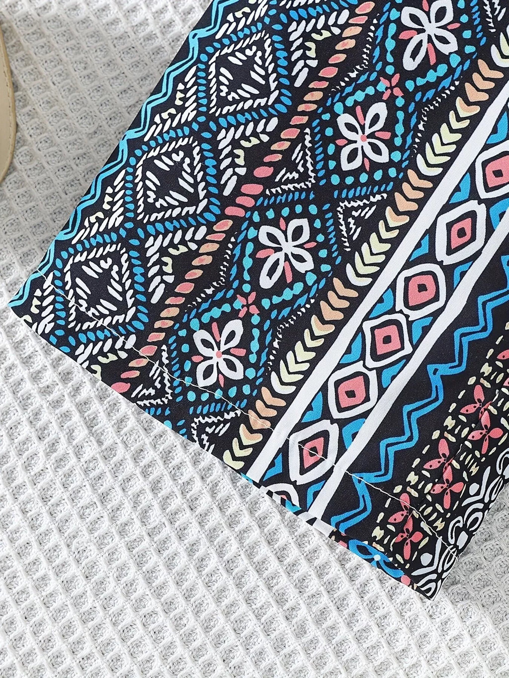Blue multicolor geometric kids wide-leg pants with floral and diamond print, hem close-up