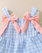 Blue gingham baby and toddler dress with oversized pink shoulder bows, upper front close-up