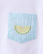 Blue striped chest pocket with embroidered lemon slice on white kids T-shirt, close-up view
