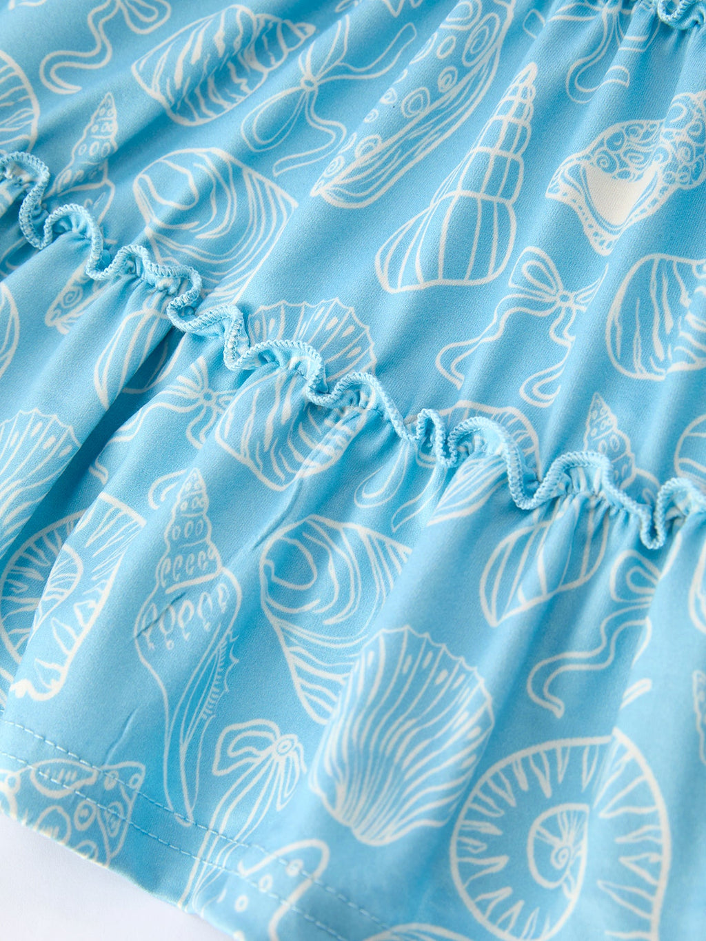Blue kids ocean dress with white seashell and starfish print, fabric close-up