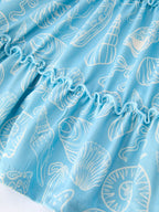 Blue kids ocean dress with white seashell and starfish print, fabric close-up
