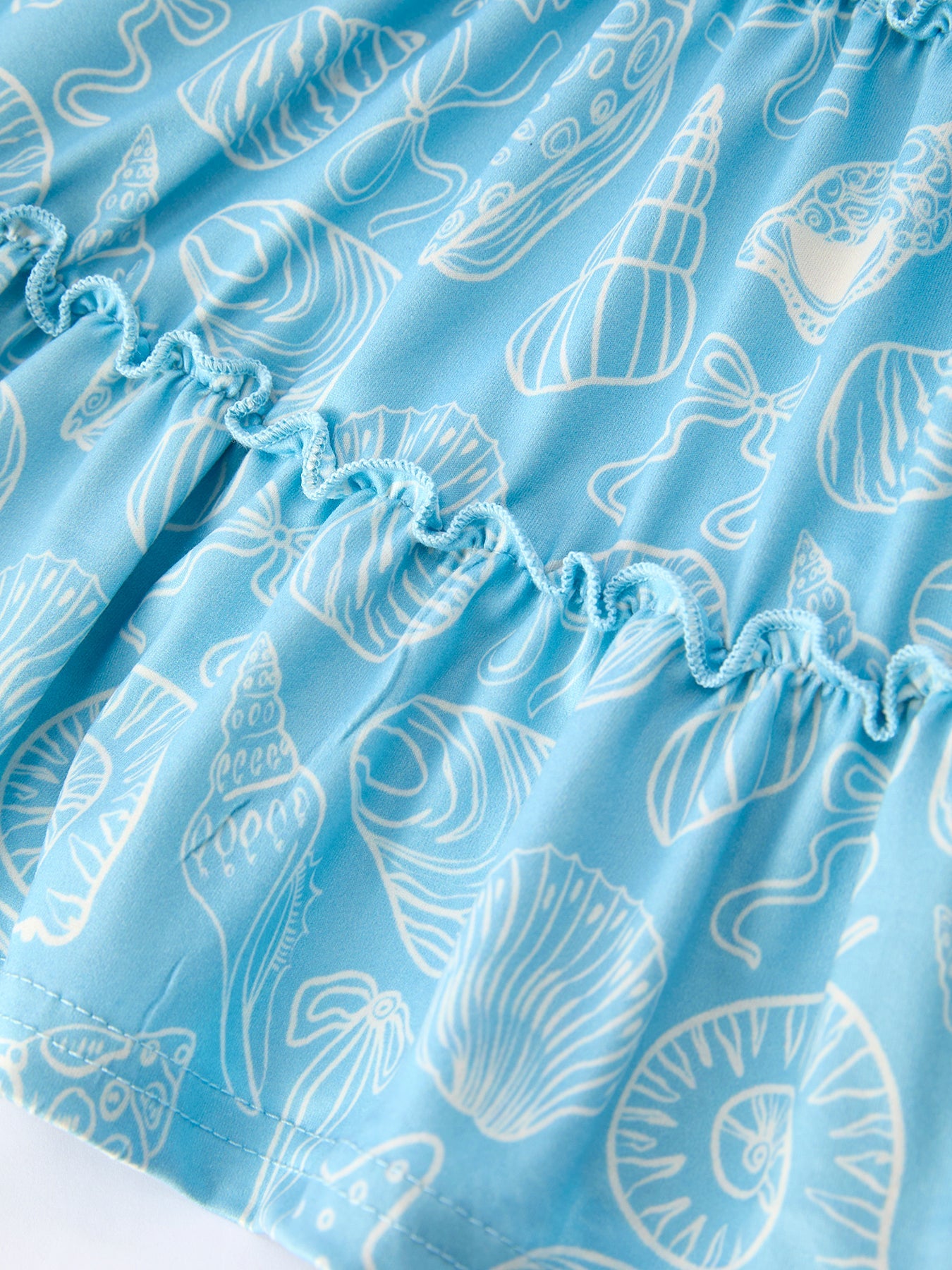 Blue kids ocean dress with white seashell and starfish print, fabric close-up