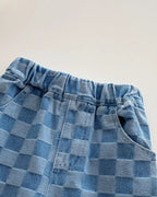 Blue checker plaid kids trousers with elastic waistband and front pocket, close-up detail