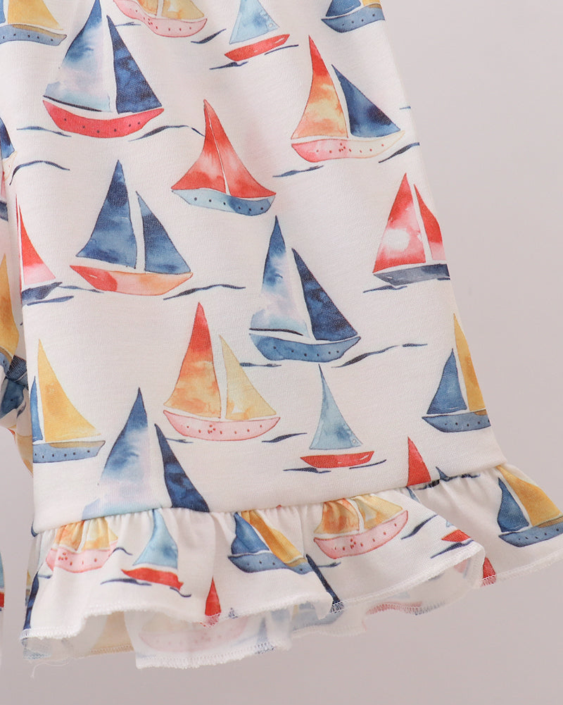 White sailboat print kids shorts with ruffle-trim hem, close-up view