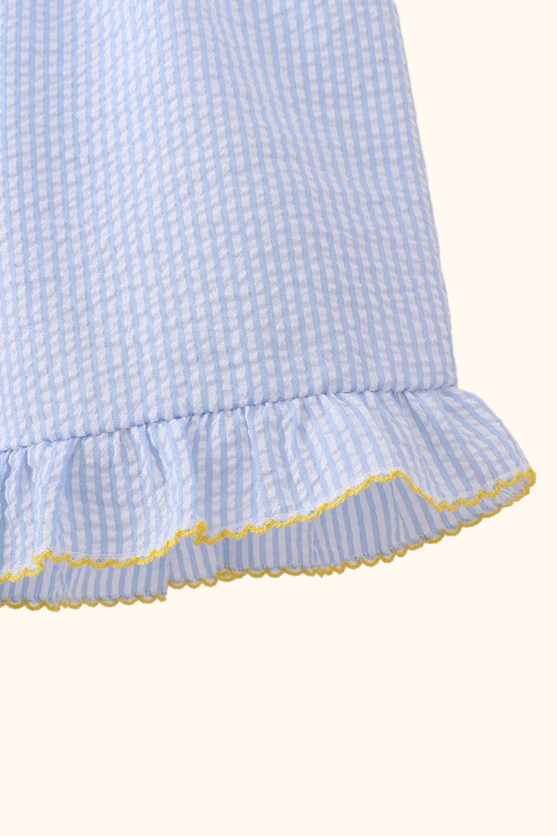 Blue striped seersucker ruffle shorts with yellow scalloped edging, close-up view