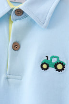 Light blue kids polo with green tractor embroidery and stitched collar, chest detail