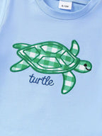 Blue baby tee with green gingham turtle appliqué and embroidered outline, front detail view