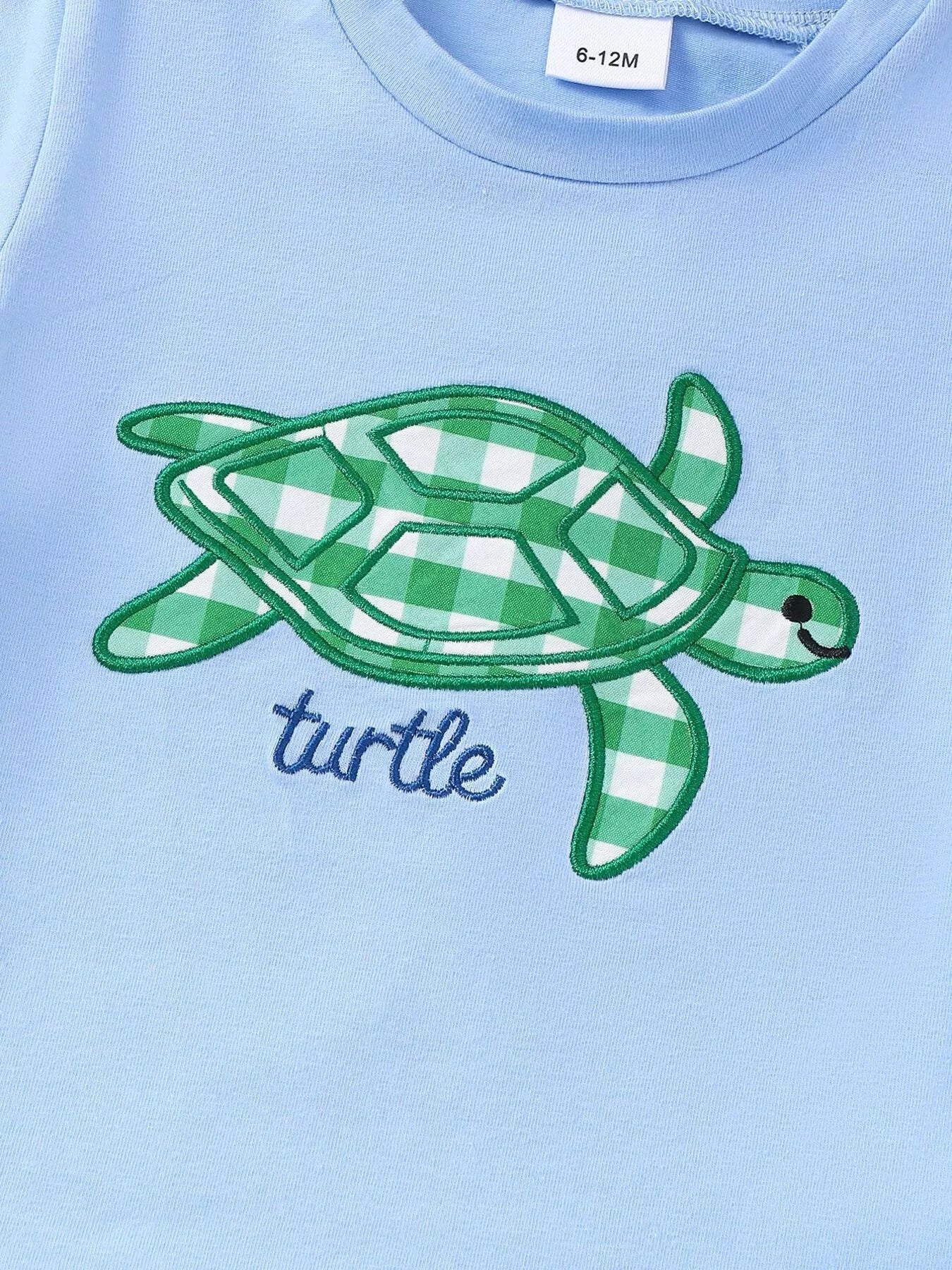 Blue baby tee with green gingham turtle appliqué and embroidered outline, front detail view