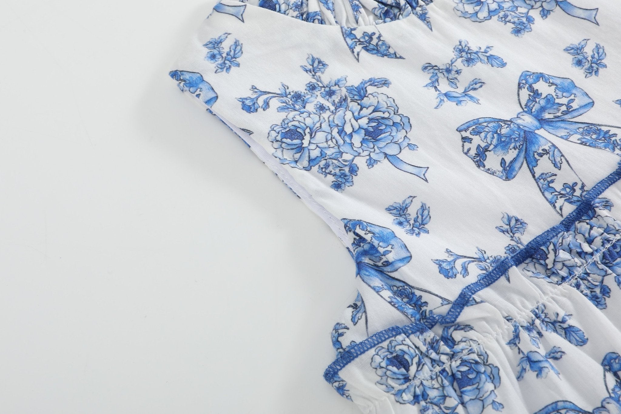 Blue and white kids layered dress with sleeveless armhole and ruffle tier, bodice detail