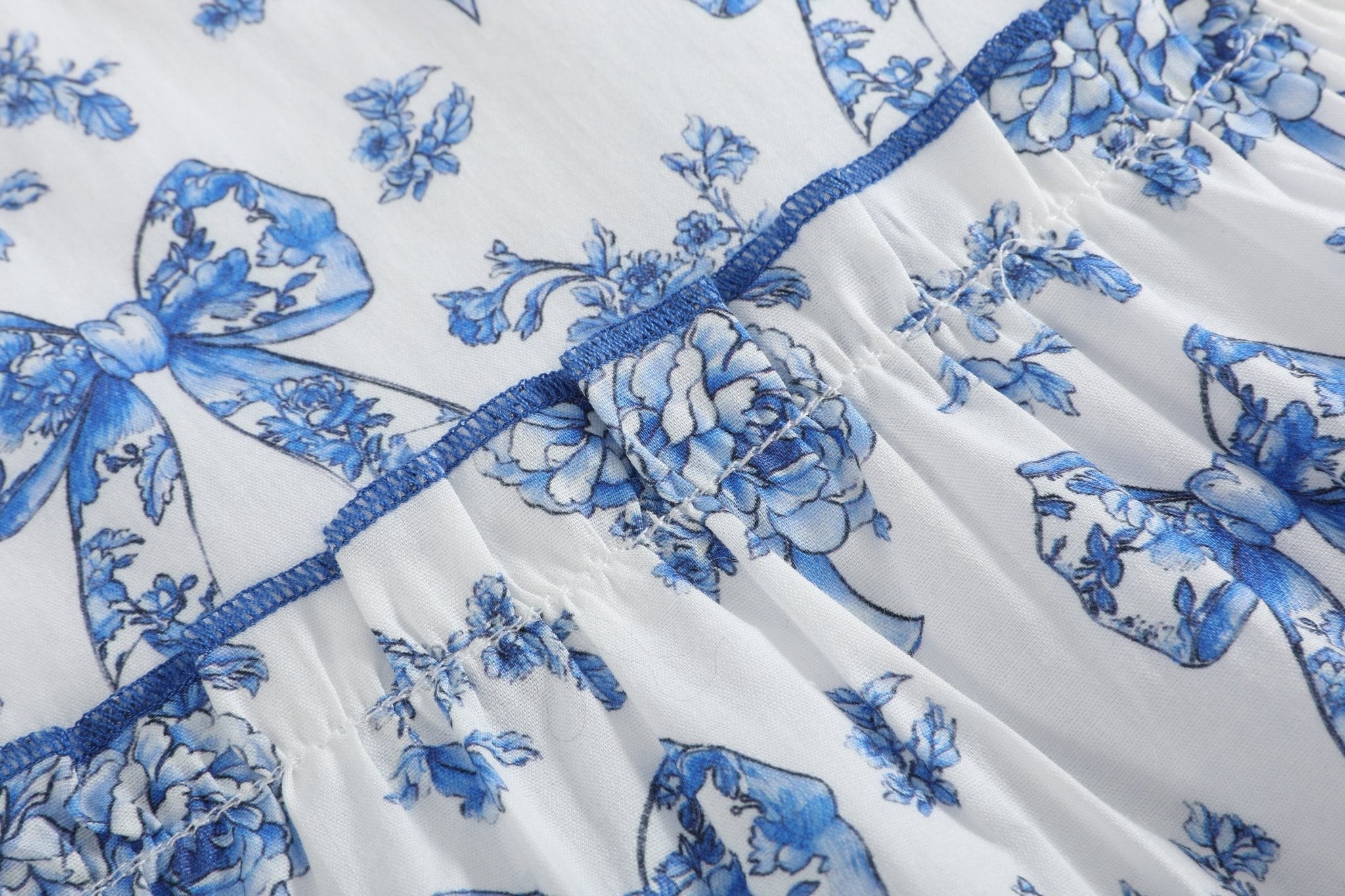 Blue and white kids dress with bow and botanical floral print, fabric close-up