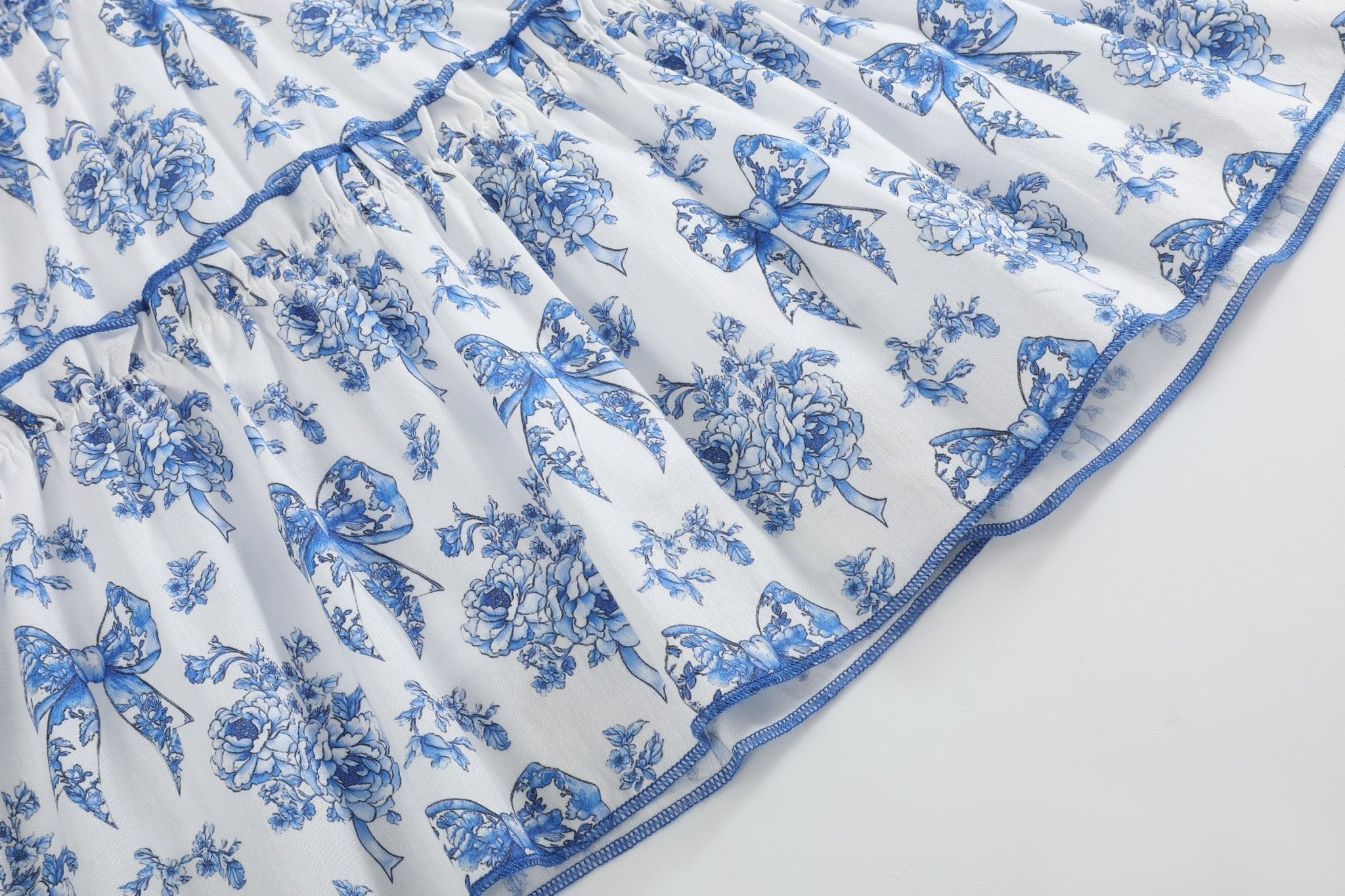 Blue and white bow floral dress with contrast-edged ruffle tiers, skirt close-up