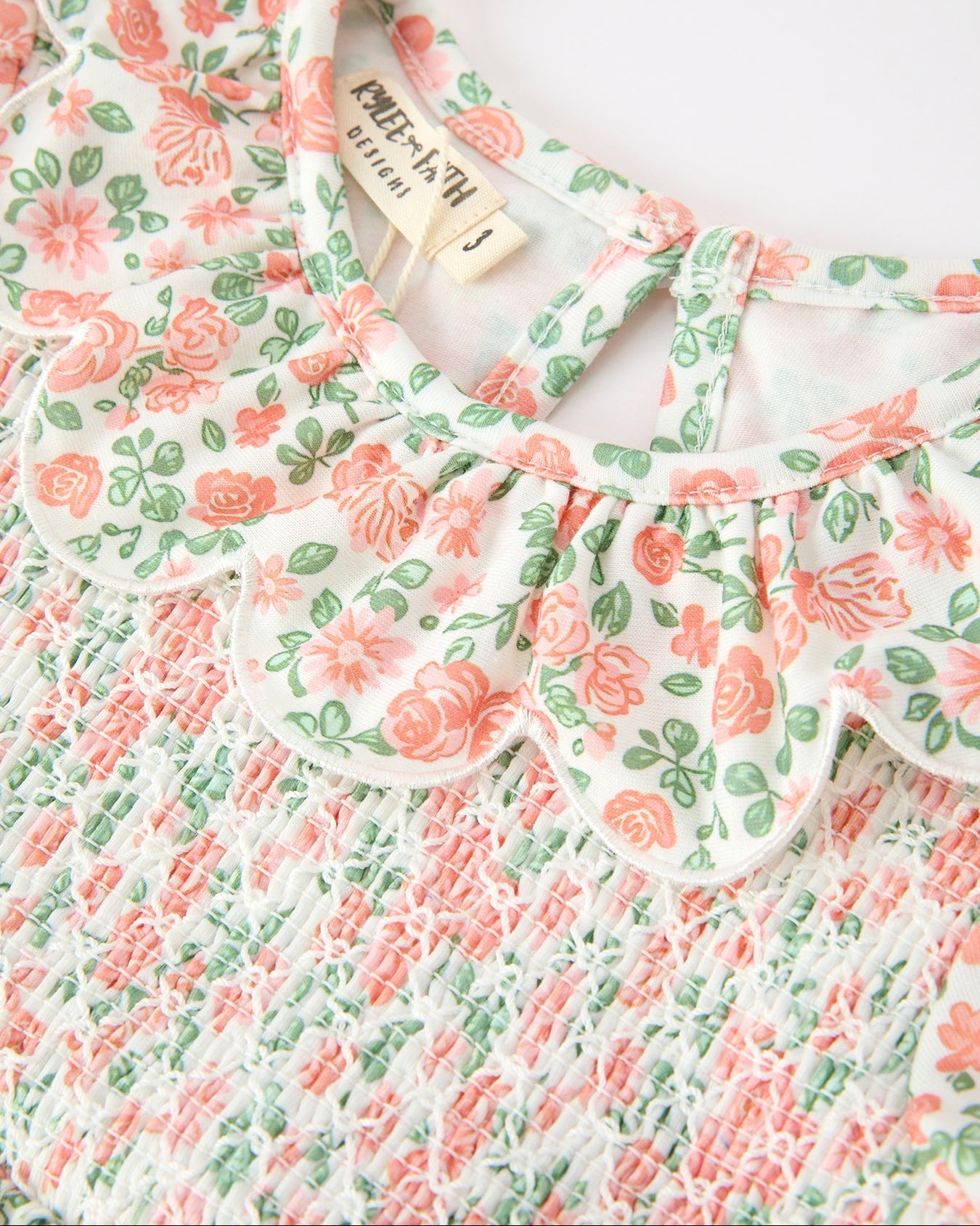 Blush floral kids dress with petal collar and smocked bodice, collar and chest close-up