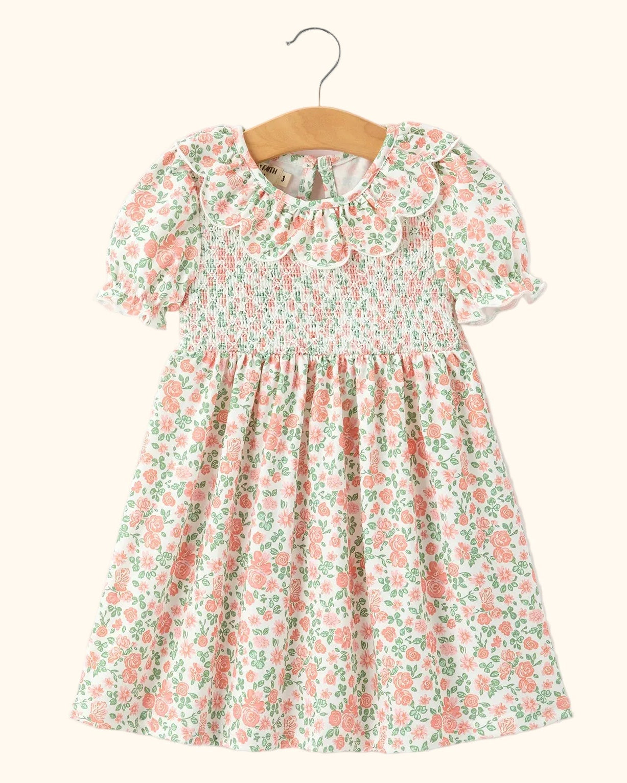 Blush floral kids smocked petal collar dress with short puff sleeves, front hanging view