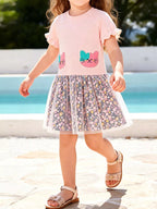 Blush pink kids cat floral tulle dress with gathered floral skirt and ruffle sleeves, modeled front view