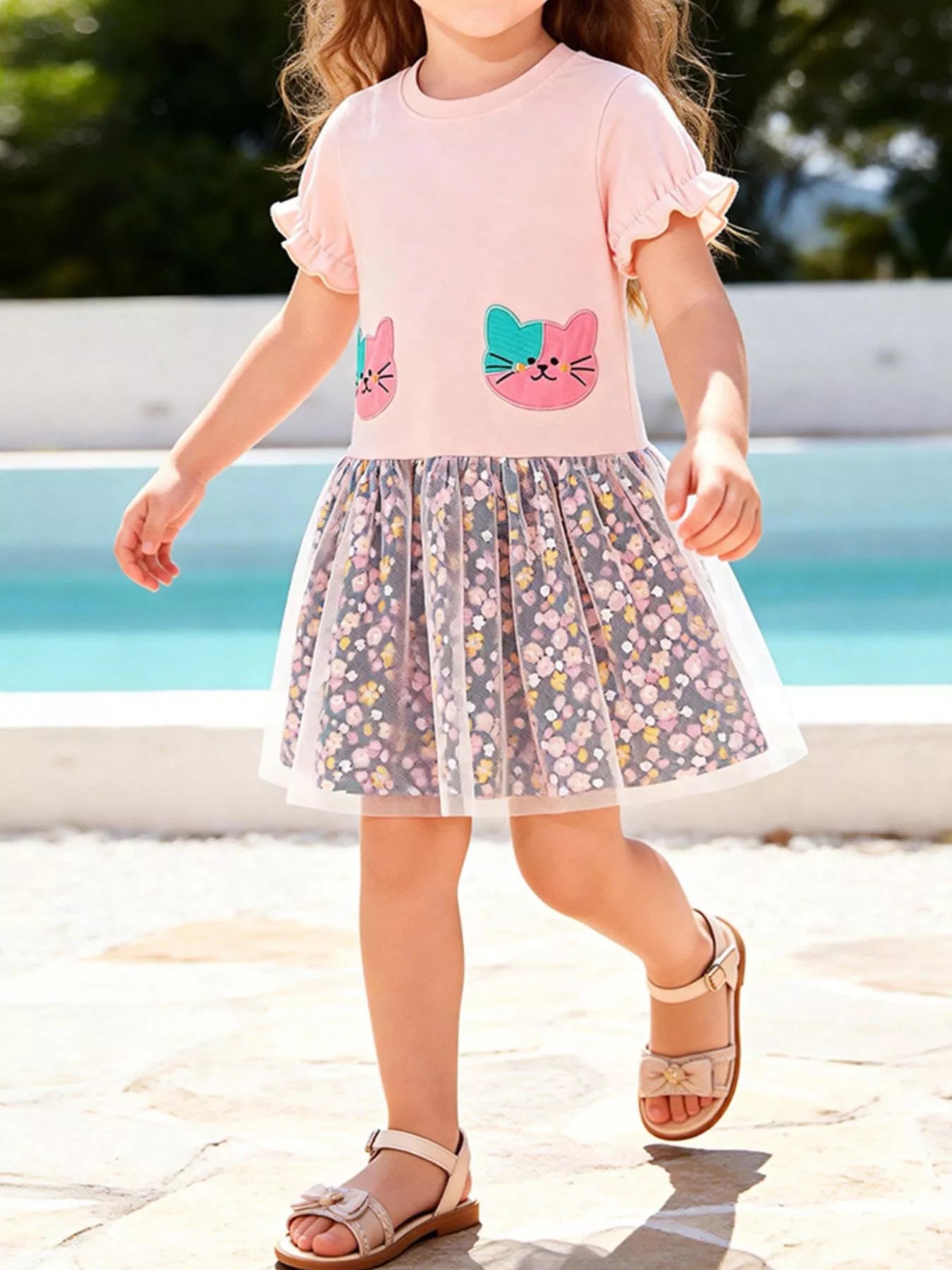 Blush pink kids cat floral tulle dress with gathered floral skirt and ruffle sleeves, modeled front view