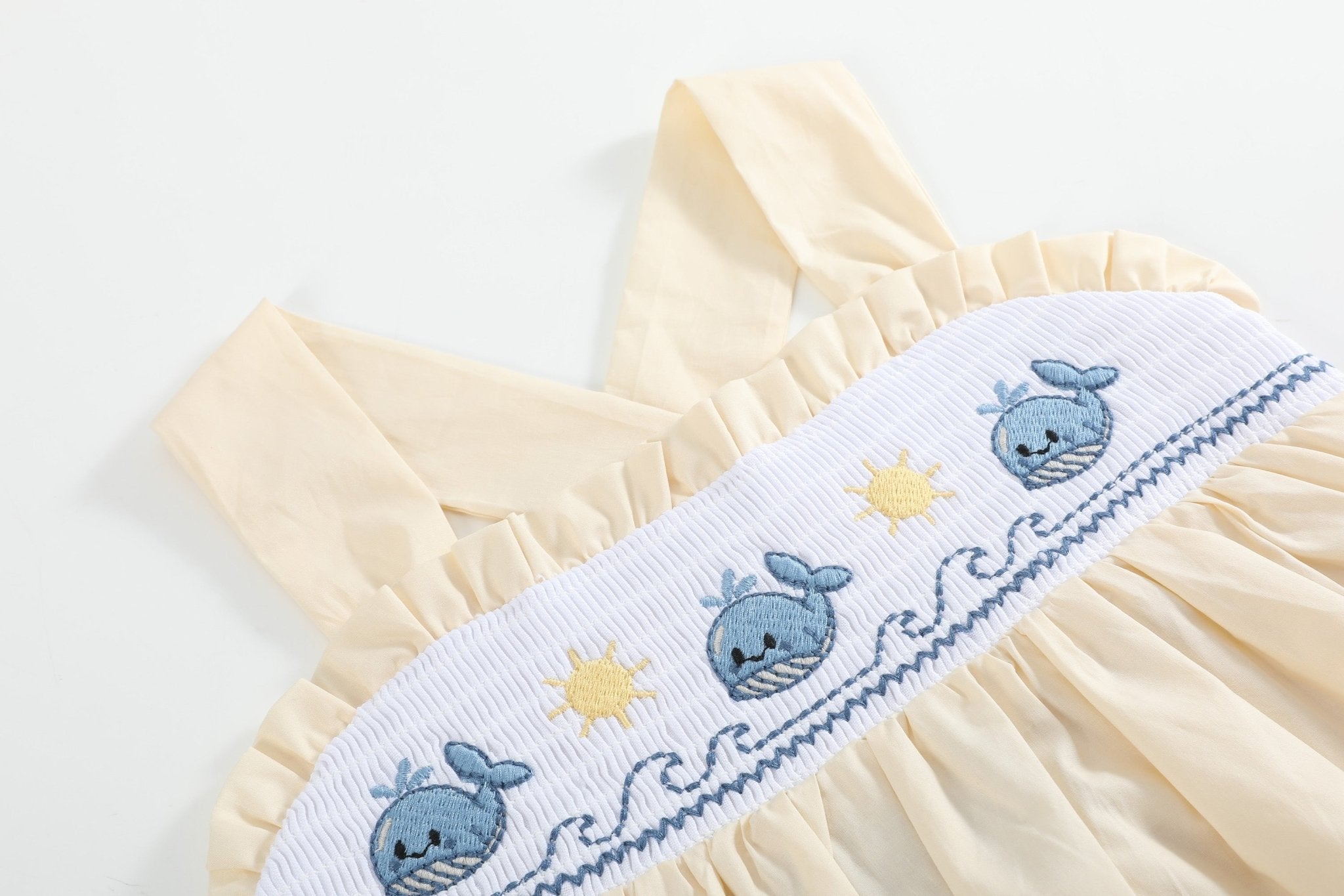 Buttercream yellow whale smocked dress with blue whales suns and waves, embroidery close-up