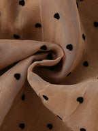Caramel sheer dress fabric with black polka dots, fabric detail view