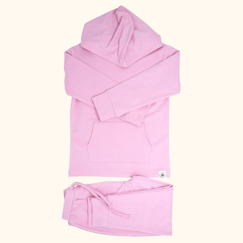 Carnation pink hooded top with kangaroo pocket and matching kids joggers, flat lay front view