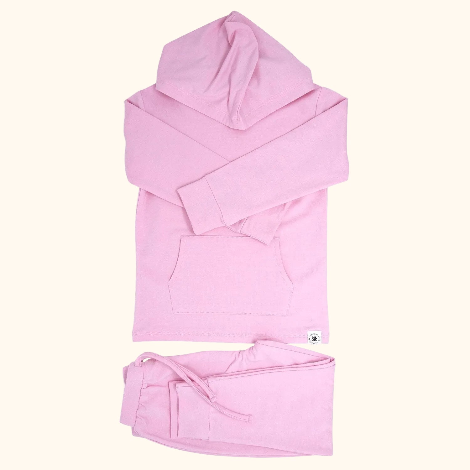 Carnation pink hooded top with kangaroo pocket and matching kids joggers, flat lay front view