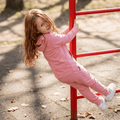 Carnation pink kids hooded jogger set with matching pants, playground side view
