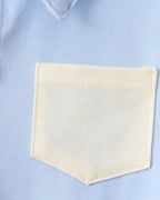 Powder blue kids collared shirt with cream contrast patch pocket, close-up view