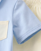 Powder blue short-sleeve shirt with cream pocket and matching shorts waistband, detail view