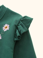 Dark green kids floral sweatshirt with layered ruffle shoulder detail, close-up