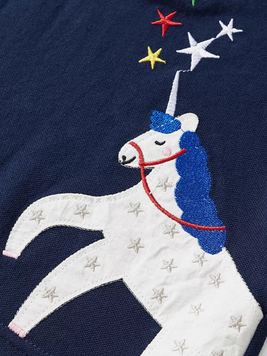 Dark navy kids polo with white unicorn appliqué and colorful embroidered stars, design close-up